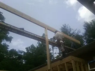 Carpenter setting a ridge beam over a new addition frame — Ice Dam Removal by Roofing Brothers in Brockport