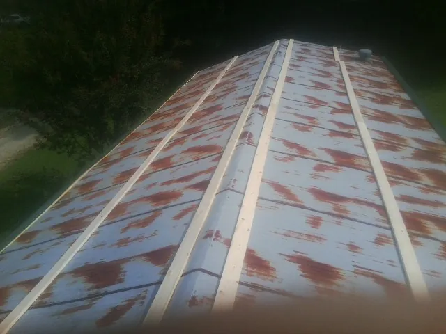 Rusted metal roof panels with new wood purlins before replacement — Storm Damage Roof Repair in Brockport by Roofing Brothers