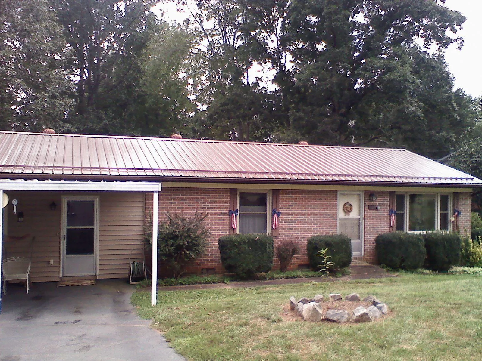 Bronze metal roof and carport on a brick ranch home — Roof Repair work by our crew in Brockport